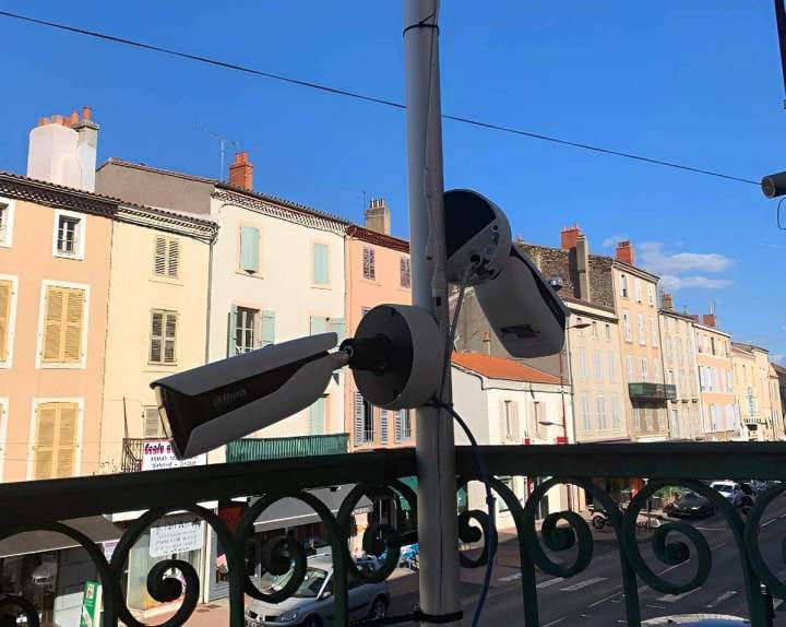 Deux caméras de vidéosurveillance orientées, posées sur un mât extérieur