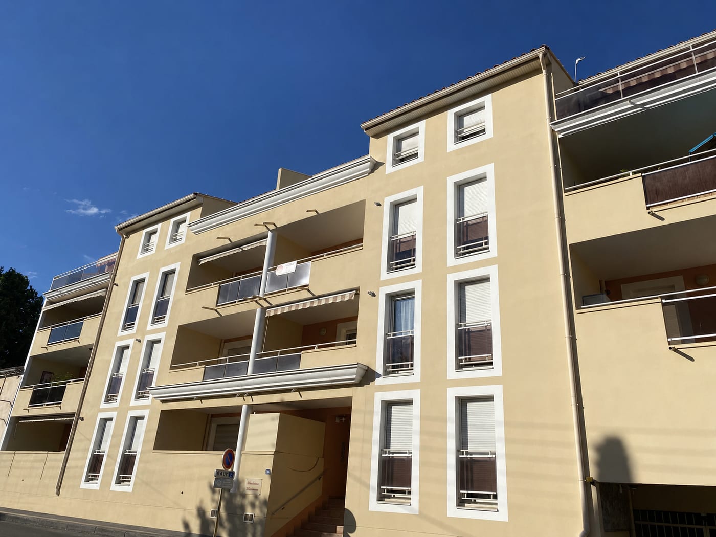 Résidence en copropriété au soleil, façades claires et balcons